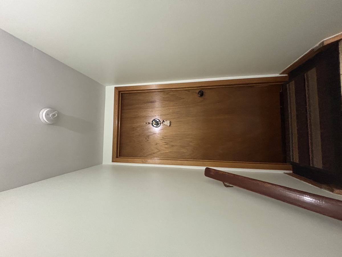 Freshly painted stairwell hallway with wood door