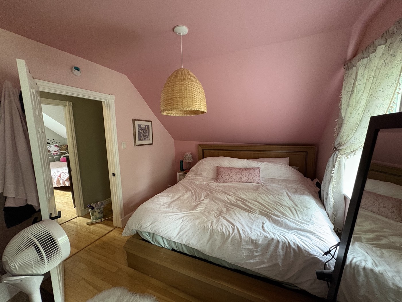 Freshly painted pink bedroom with wood bed frame