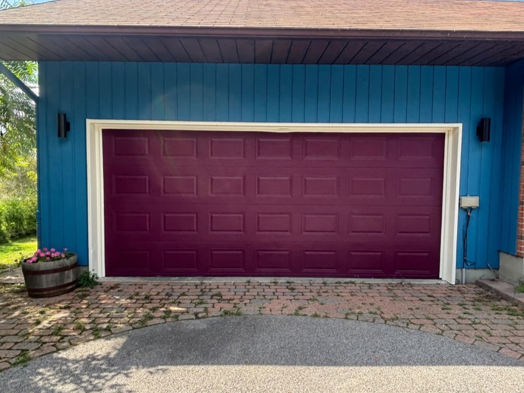 Freshly painted blue exterior siding with a magenta garage door